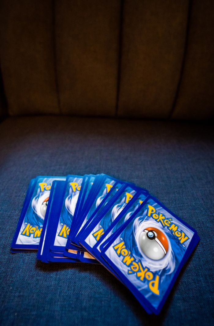Collection of Pokemon trading cards fanned out on a sofa. Ideal for gaming and collectibles imagery.